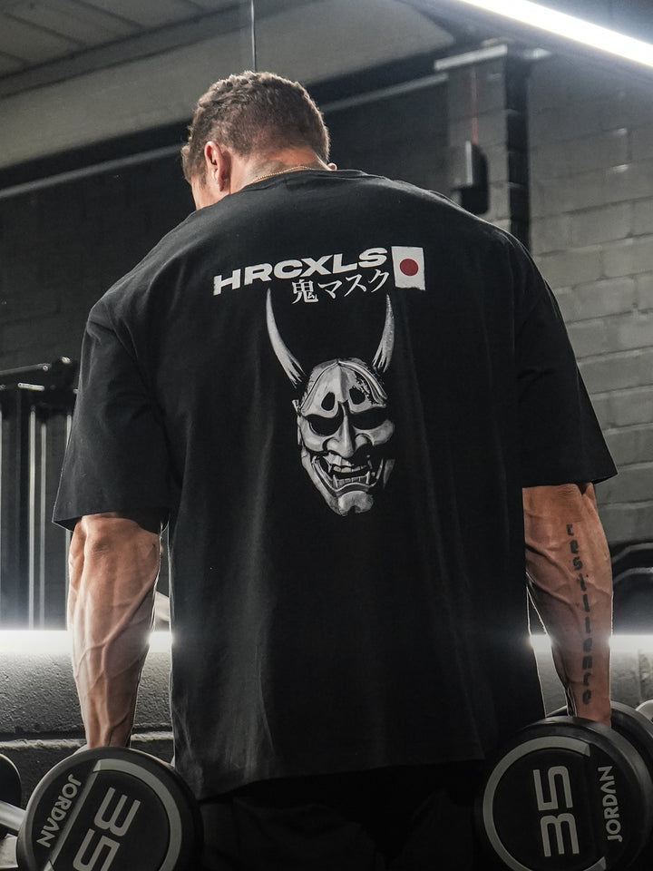 Athlete wearing the black HERCXLES Oni oversized T-shirt from the back in the gym