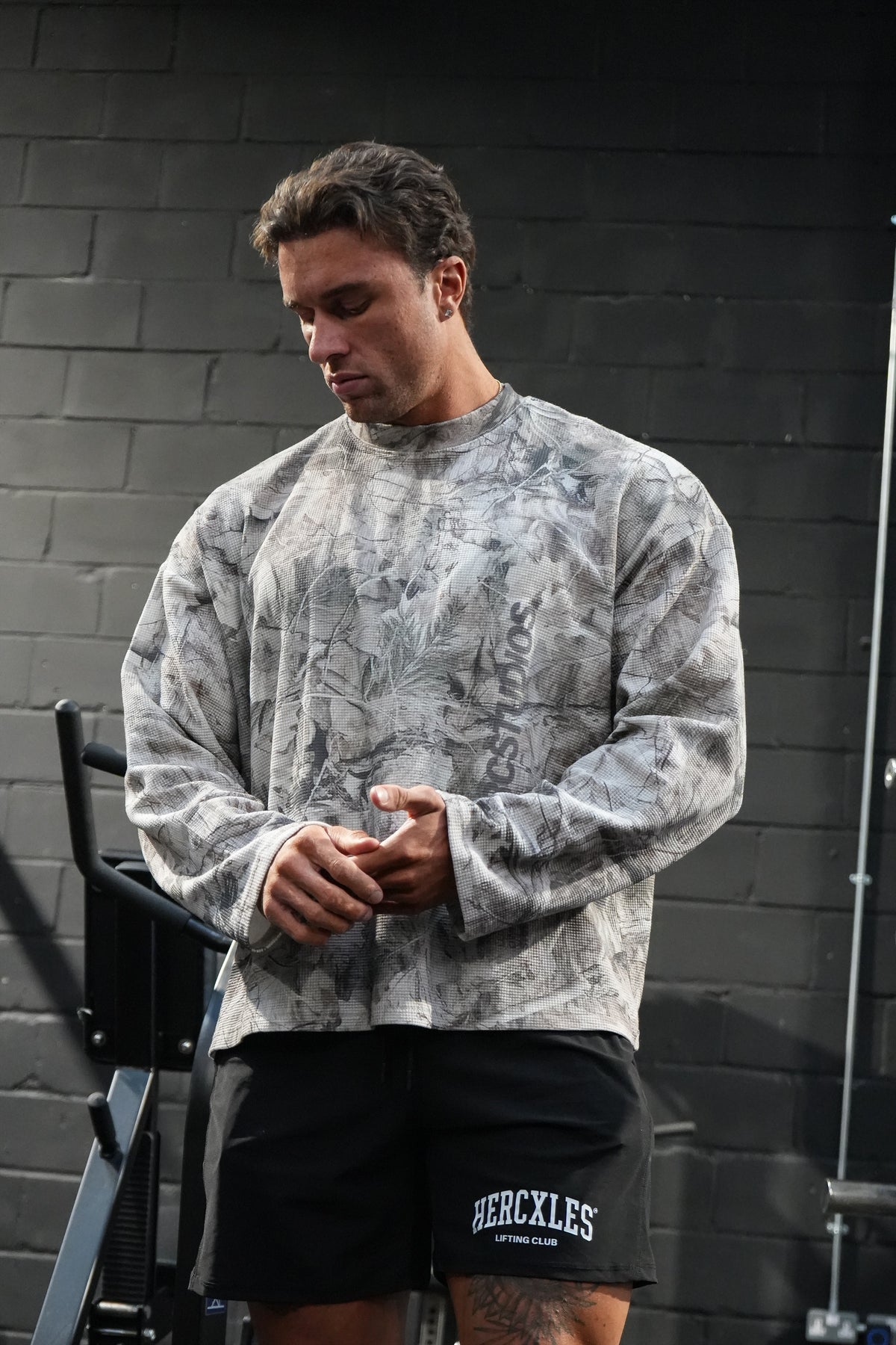 HERCSTUDIOS CAMO LONG SLEEVE - Tree Camo model front view with hands together