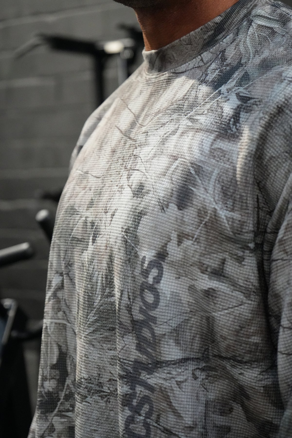 HERCSTUDIOS CAMO LONG SLEEVE - Tree Camo model close-up of waffle texture and chest print