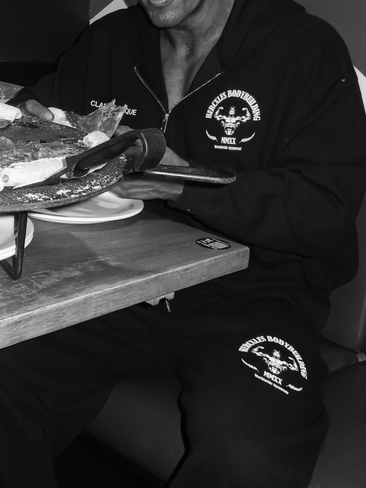 Worldwide Competitor Zip Hoodie - Black / White model seated in zip hoodie and matching joggers (p2)